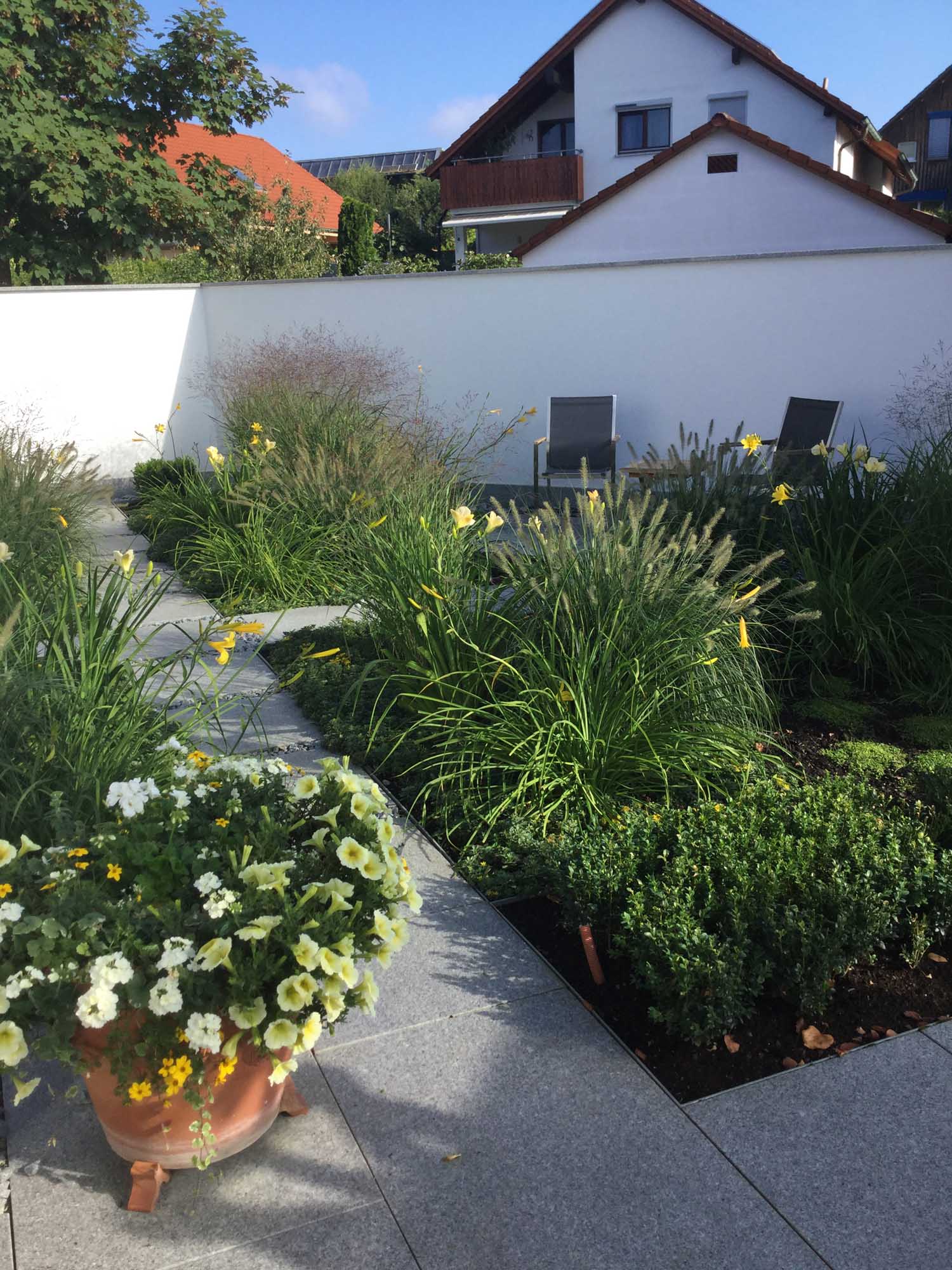 Vorgarten, Taglilien & Gräser im umfriedeten Hof